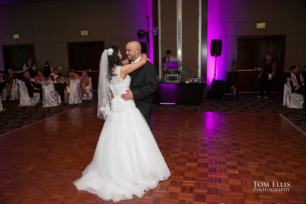 Bride and groom share their first dance, with a backdrop of purple up-lighting