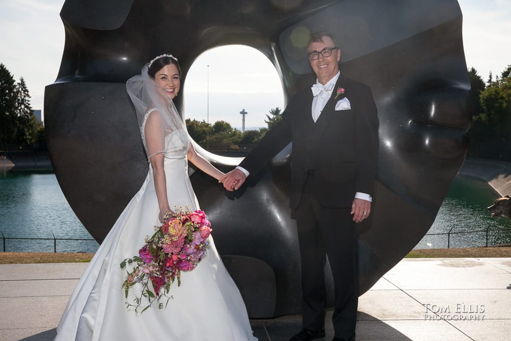 Seattle wedding photography - Bride and groom pose in front of the circular "donut" sculpture at Volunteer Park in Seattle