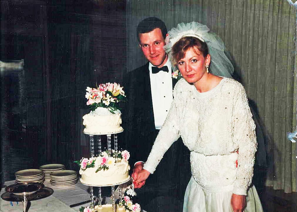 Photo of bride and groom preparing to cut their wedding cake